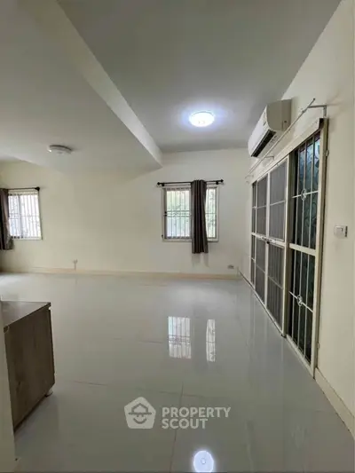 Spacious living room with large windows and air conditioning in modern apartment.