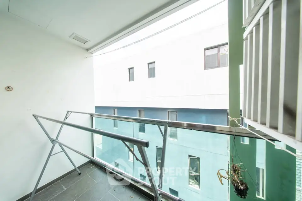 Modern balcony with glass railing and urban view, perfect for city living.