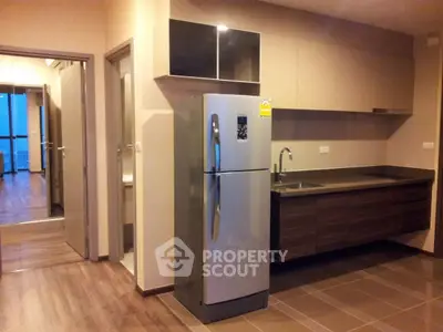 Modern kitchen with sleek design and stainless steel fridge in a stylish apartment.