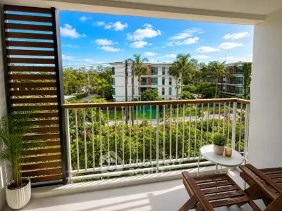 Spacious balcony with lush garden view in modern apartment complex
