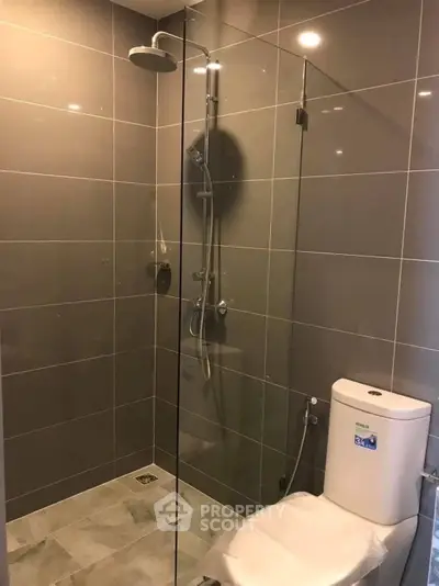 Modern bathroom with glass shower enclosure and sleek tile design.