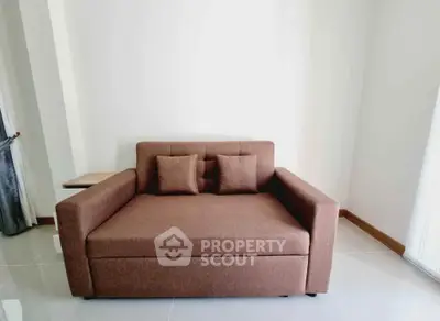 Cozy brown sofa in a minimalist living room with glossy tiled floors.
