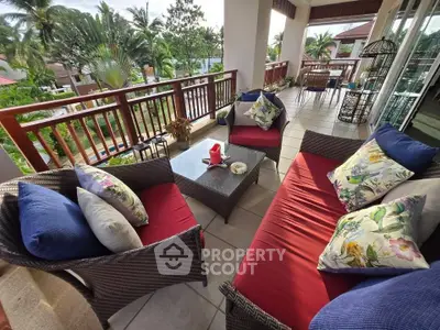 Spacious balcony with cozy seating and lush garden view, perfect for relaxation.