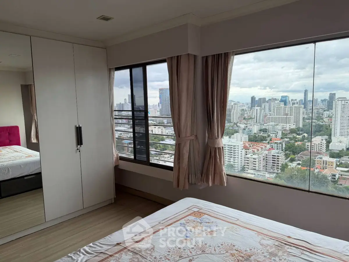 Spacious bedroom with panoramic city view and elegant decor