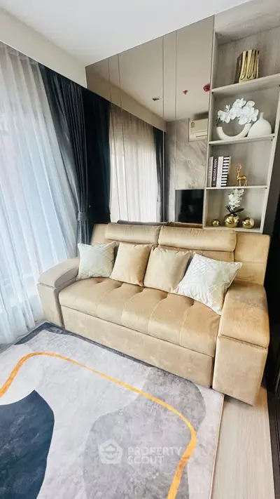 Stylish living room with plush beige sofa, elegant decor, and floor-to-ceiling windows for natural light.