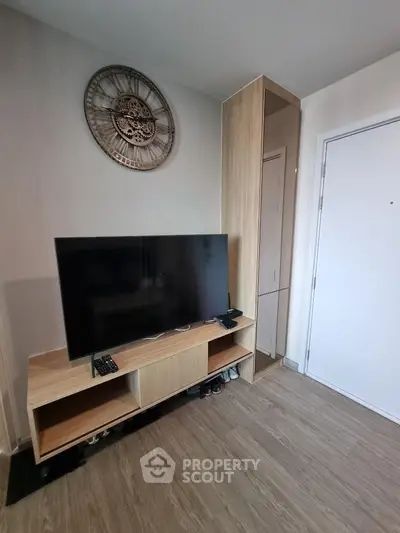 Modern living room with stylish TV stand and wall clock, showcasing contemporary interior design.