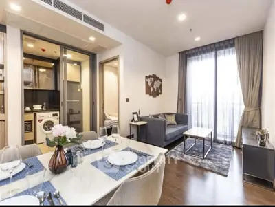 Modern living room with dining area and balcony access in stylish apartment.