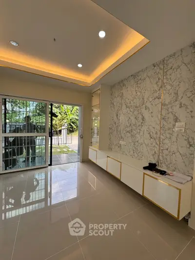 Modern living room with marble accent wall and sleek lighting