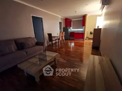 Spacious open-plan living room with modern kitchen and wooden flooring