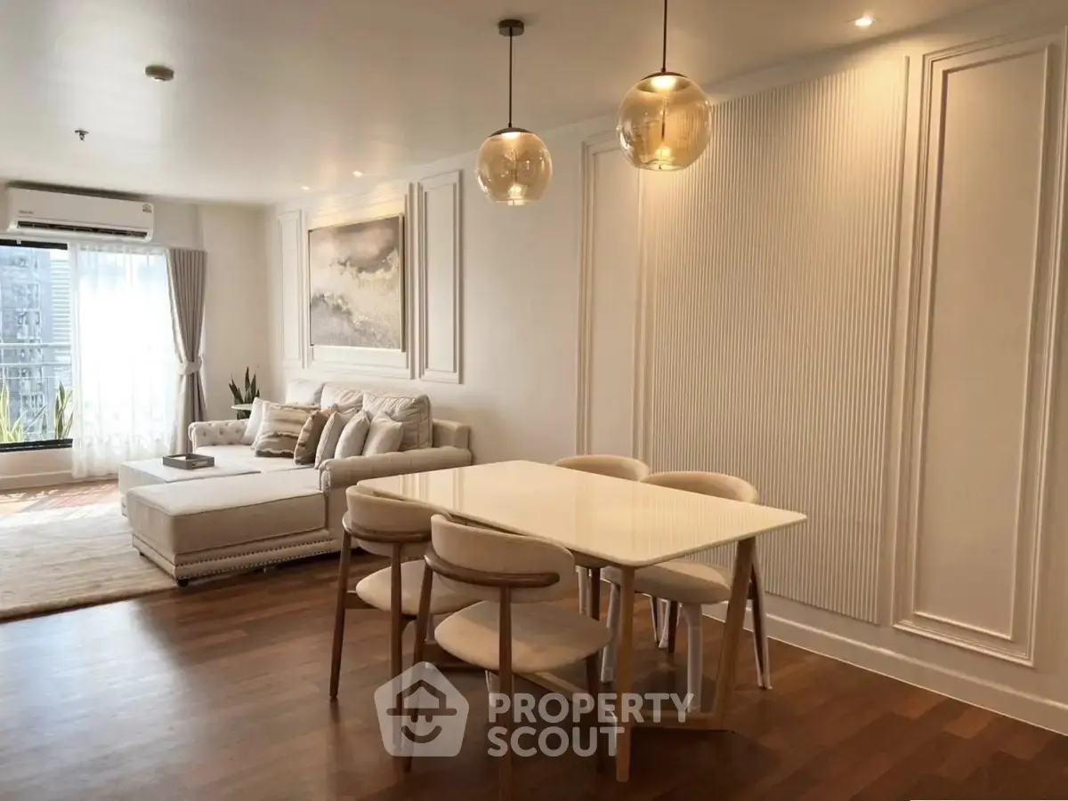 Elegant living room with modern dining area and stylish lighting in a cozy apartment.