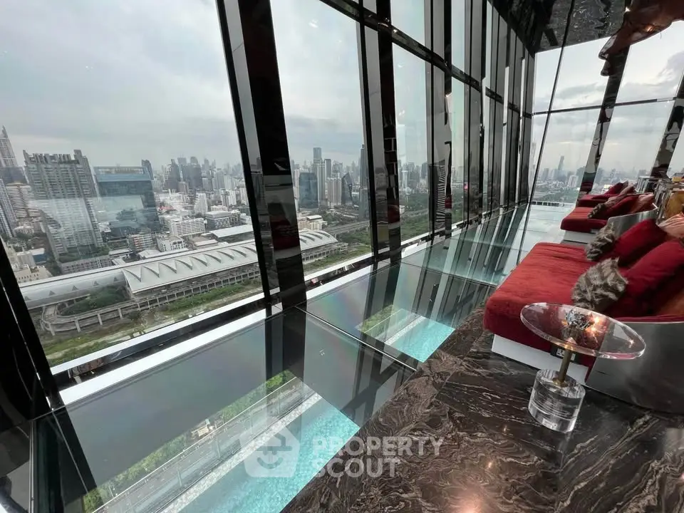 Luxurious high-rise living room with panoramic city views and modern glass design.