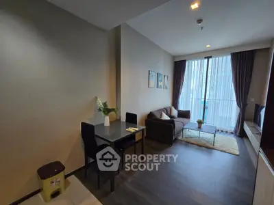 Modern living room with cozy sofa, dining table, and large window for natural light.