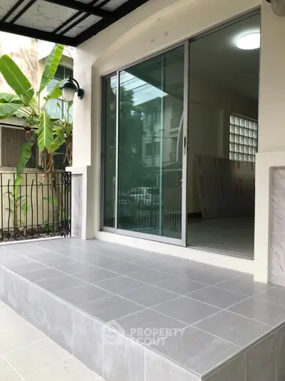 Modern balcony with sliding glass doors and tiled flooring in urban setting