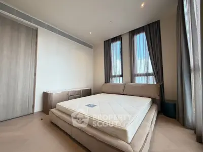 Spacious bedroom with large windows and modern furnishings