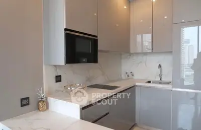 Modern kitchen with sleek cabinetry and marble countertops in a high-rise apartment.