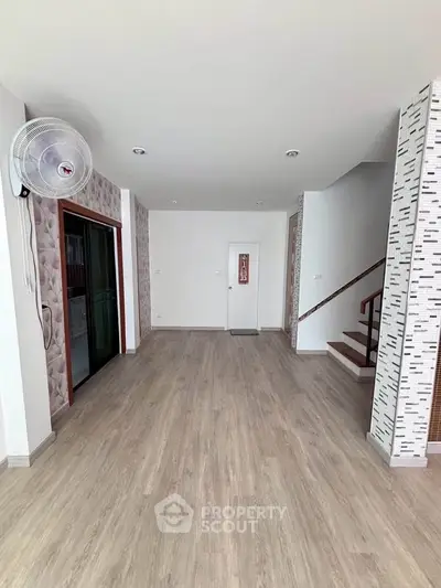 Spacious modern living room with stylish flooring and unique wall design, perfect for contemporary living.