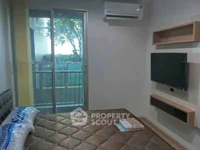 Modern bedroom with balcony access and wall-mounted TV in a stylish apartment.