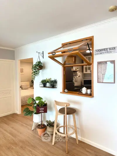 Charming open kitchen with bar stool and cozy decor, perfect for modern living.