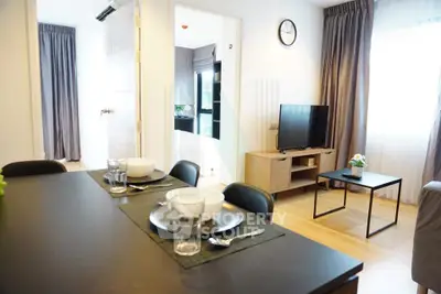 Modern apartment interior with dining area and cozy living room featuring natural light and stylish decor.