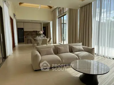 Luxurious open-plan living room with elegant decor and floor-to-ceiling windows