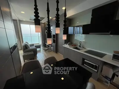 Modern open-layout kitchen and living room with ocean view, sleek design and stylish lighting.