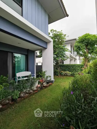 Charming garden view of modern townhouse with lush greenery and cozy outdoor seating.