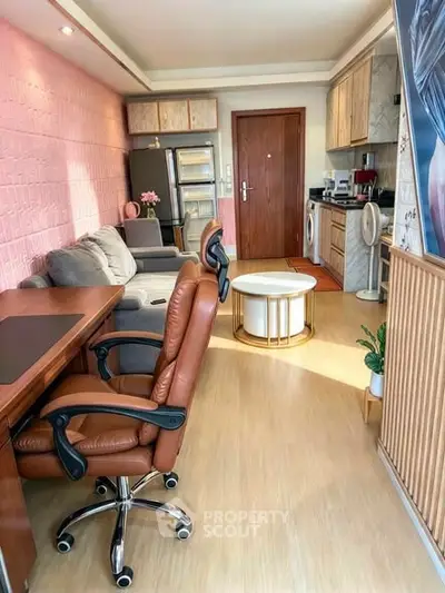 Stylish living room with modern furniture and compact kitchen in open layout apartment.