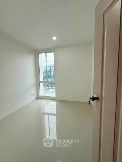 Bright and spacious empty room with large window and glossy tiled floor, perfect for customization.