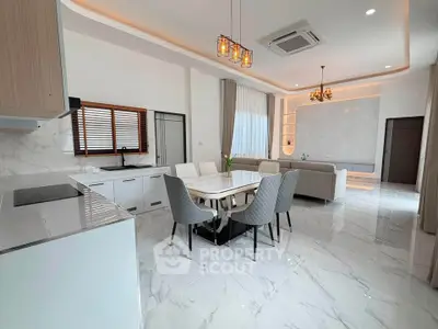 Luxurious open-plan living room and kitchen with modern decor and marble flooring.