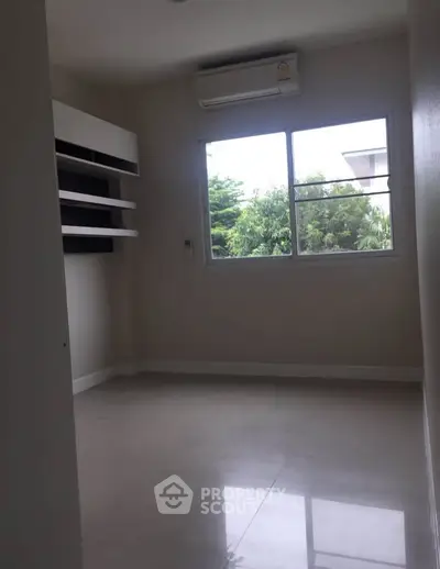 Spacious room with large window and air conditioning, perfect for a cozy living space.
