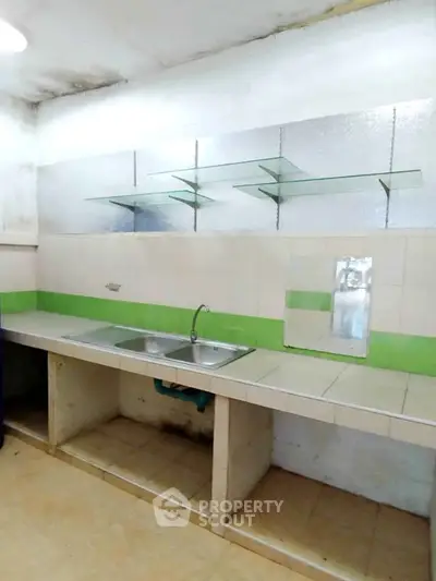 Simple kitchen with tiled countertops and glass shelves