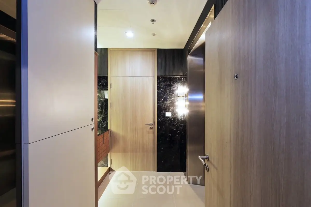 Modern apartment entrance with sleek wooden doors and elegant lighting
