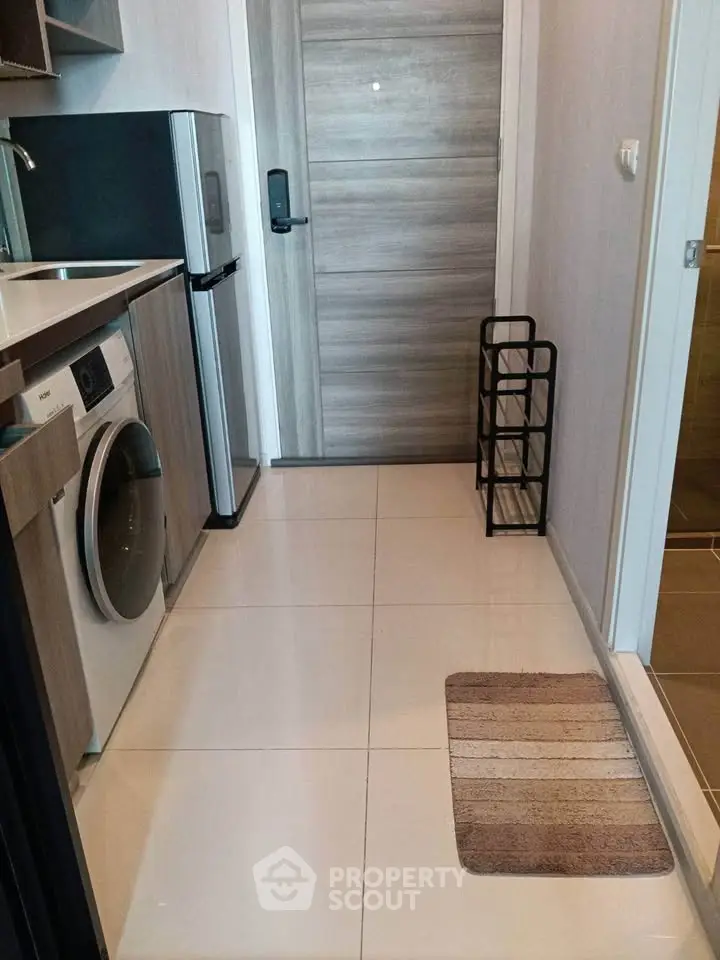 Modern apartment entrance with washing machine and sleek kitchen design