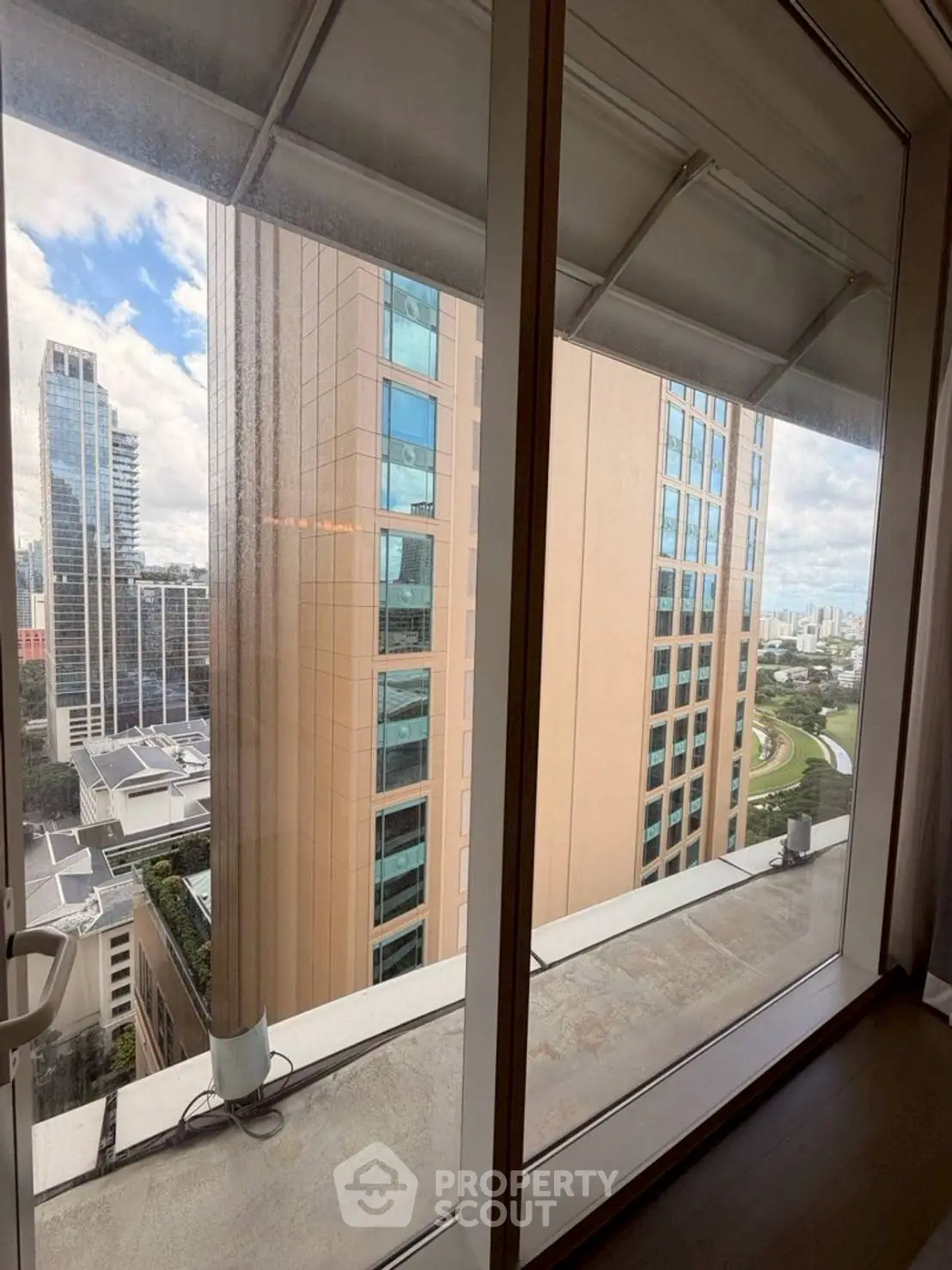 Stunning high-rise view from a modern apartment window showcasing urban skyline.