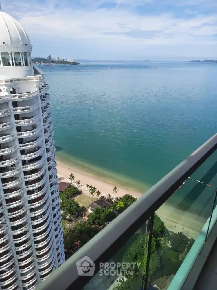 Stunning ocean view from high-rise balcony overlooking pristine beach and azure waters.
