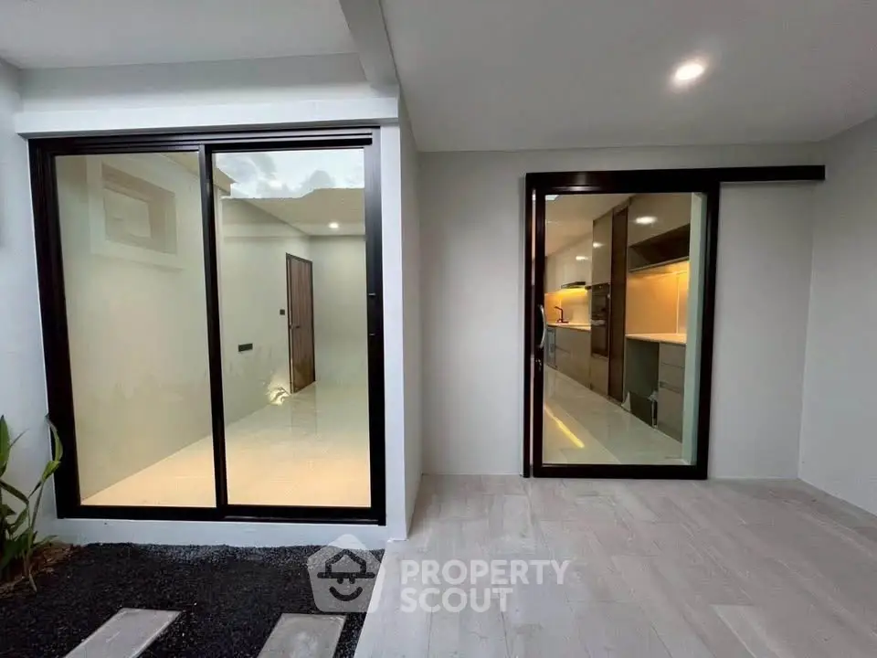 Modern home entrance with sliding glass doors and sleek interior view