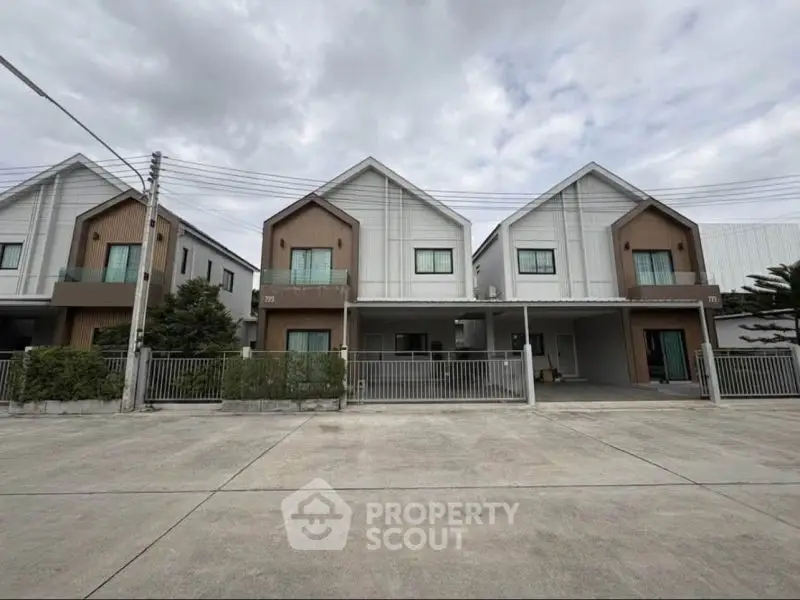 Modern townhouse exterior with minimalist design and spacious driveway