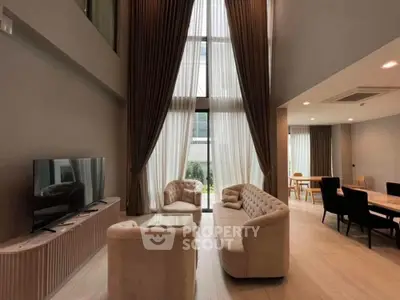 Luxurious high-ceiling living room with elegant furniture and large windows