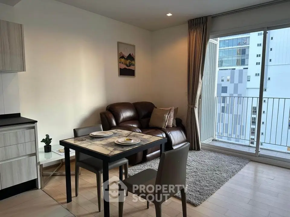 Modern living room with cozy seating and dining area, featuring a balcony with city view.