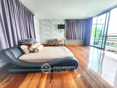 Spacious bedroom with modern design and large windows offering natural light and scenic views.