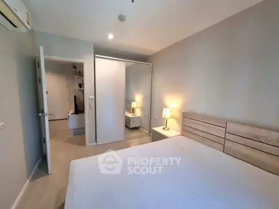 Modern bedroom with mirrored closet and ambient lighting in stylish apartment.