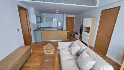 Modern open-layout living room with sleek kitchen and cozy seating area, perfect for urban living.