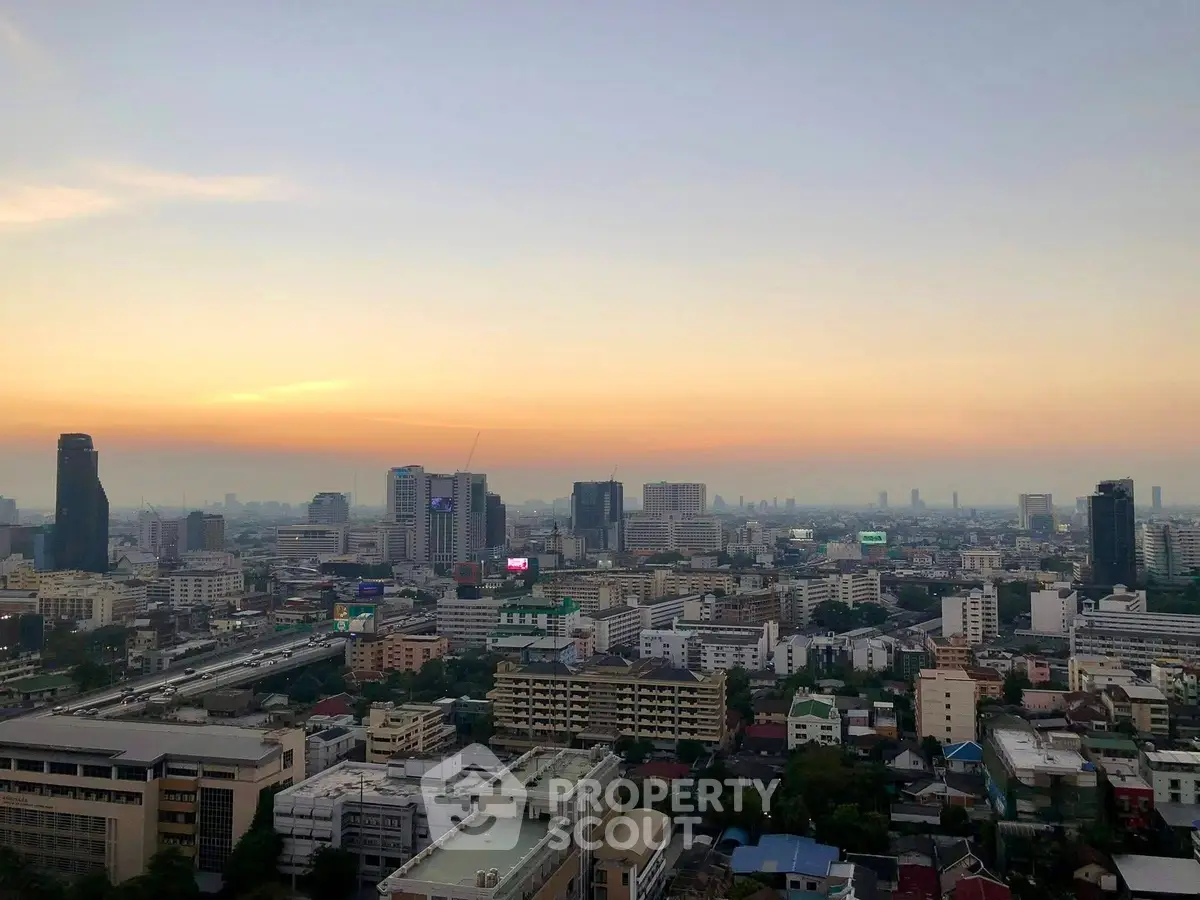 Stunning cityscape view from a high-rise building at sunset, showcasing urban skyline and vibrant city life.