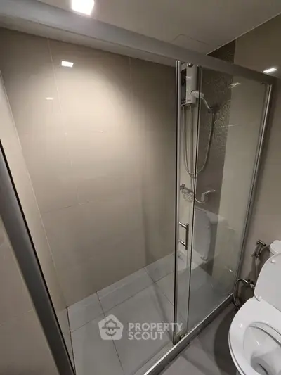 Modern bathroom with glass shower enclosure and sleek fixtures