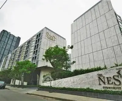 Modern urban apartment complex with sleek architecture and lush greenery.