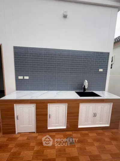 Modern kitchen with sleek cabinetry and stylish backsplash in a contemporary home.