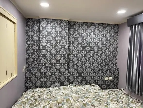 Stylish bedroom with patterned wallpaper and cozy bedding