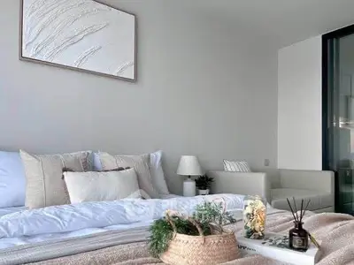Elegant bedroom with modern decor and cozy ambiance, featuring neutral tones and stylish furnishings.