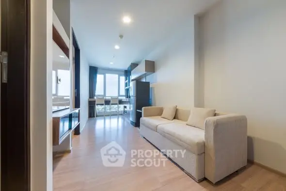 Spacious modern living room with natural light and stylish furnishings.