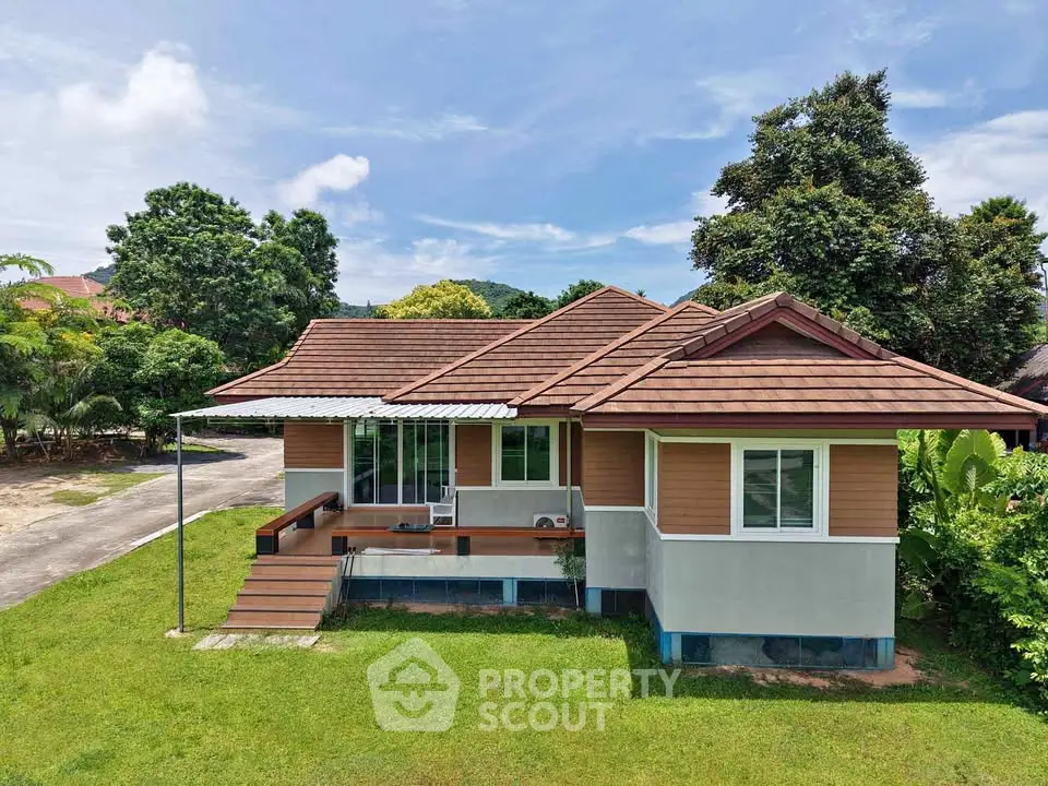 Charming single-story house with lush green surroundings and modern design.